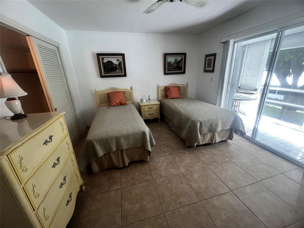 2050 Northeast 39th Street, Unit 209W Lighthouse Point, FL 33064 - Photo 16 of 27 a spacious bedroom with a bed and a flat tv screen on the dresser