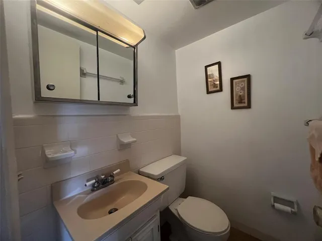 a bathroom with a sink mirror and toilet