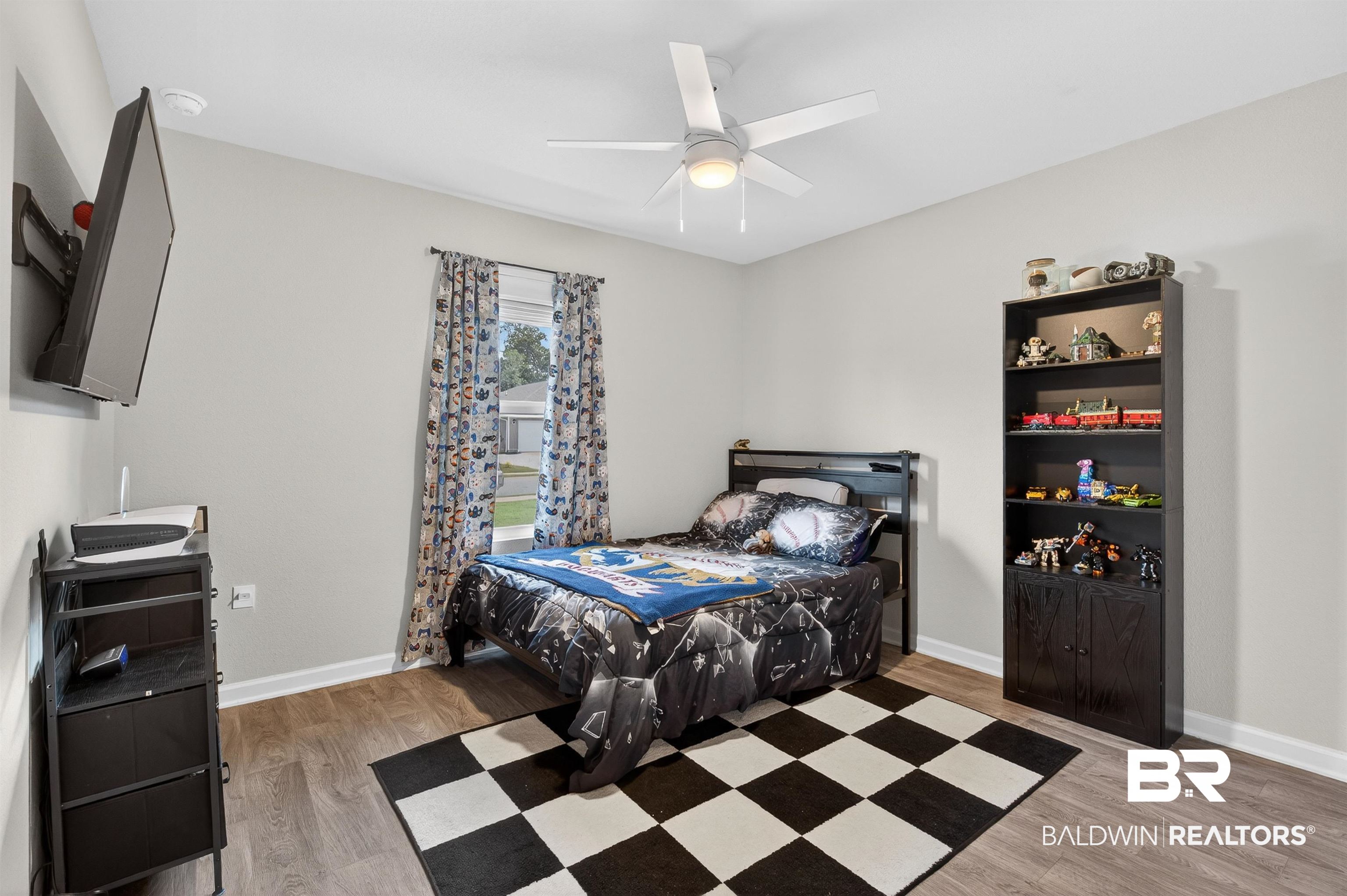 3213 Camino Real Loop Lillian, AL 36549 - Photo 47 of 61 Bedroom featuring wood-finish flooring, a ceiling fan with integrated lighting, and a window with blinds and curtains