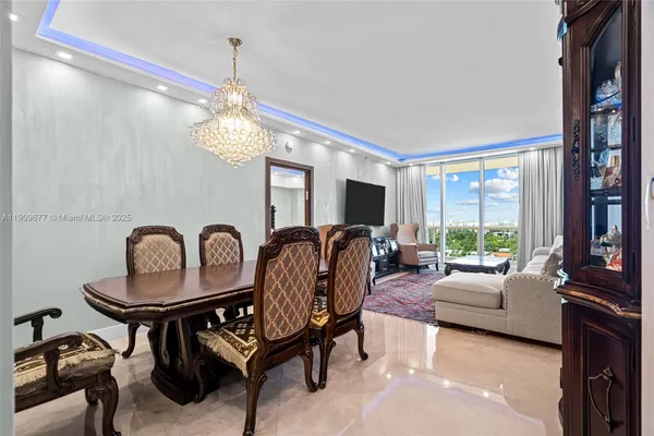 a living room with furniture a large window and a chandelier