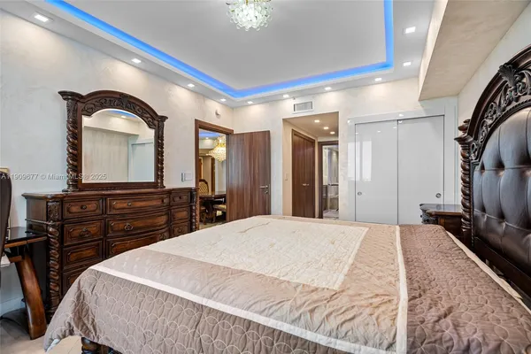 a large bedroom with a bed and a dresser with mirror