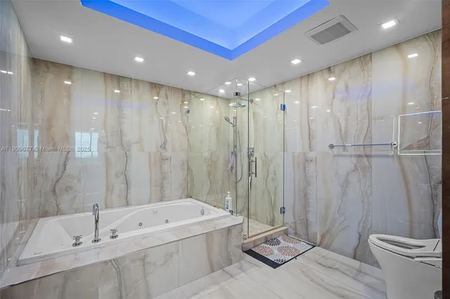 a bathroom with a tub a toilet and a shower