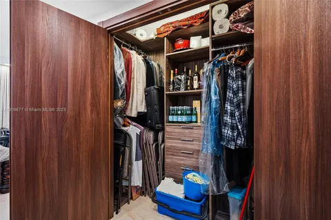 a view of walk in closet with clothes