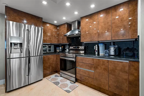 a kitchen with stainless steel appliances granite countertop a refrigerator and a stove