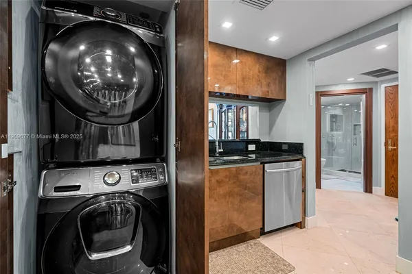 a view of washer and dryer with kitchen in the background