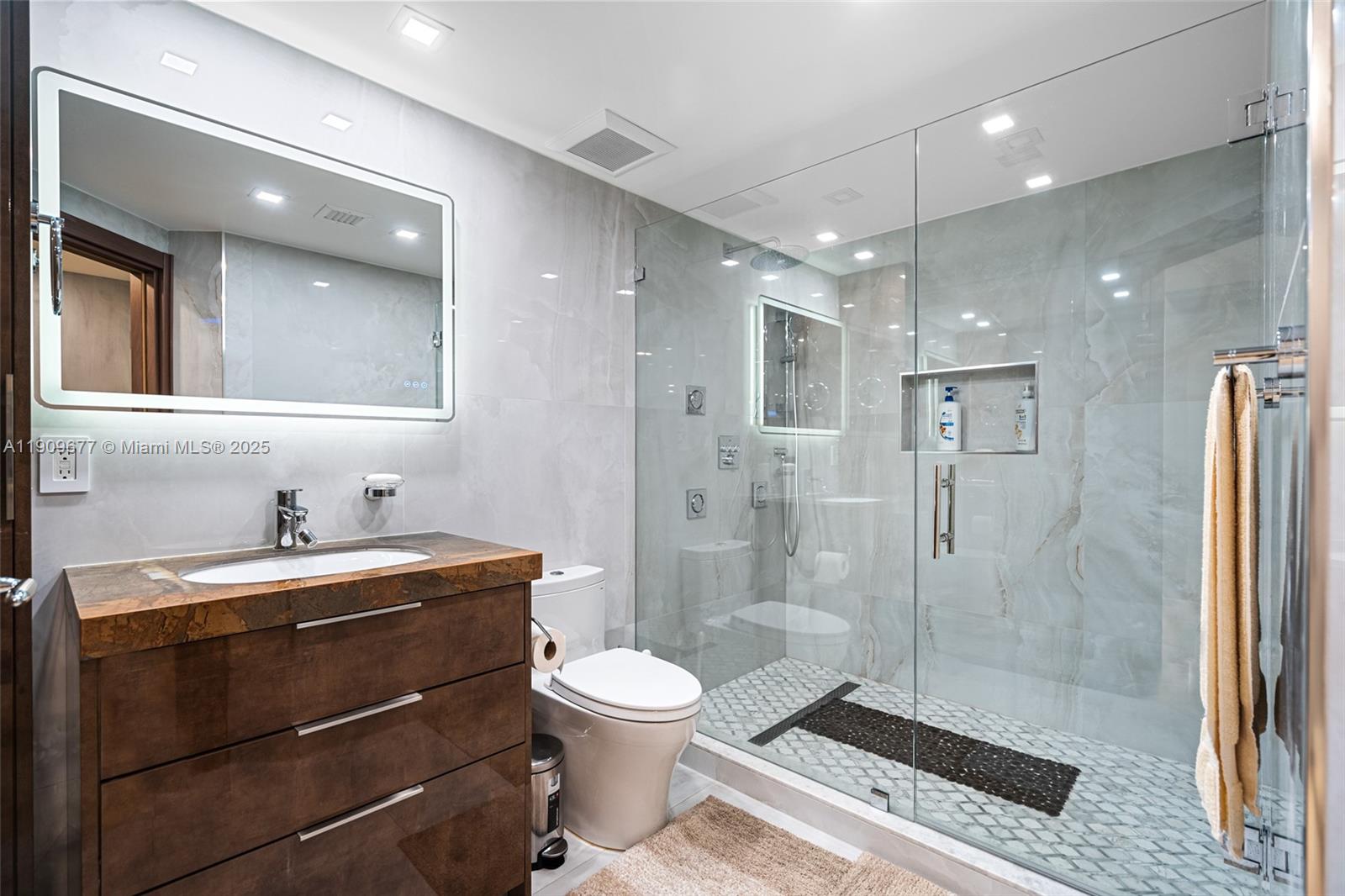 9559 Collins Avenue, Unit S8F Surfside, FL 33154 - Photo 10 of 27 a bathroom with a shower a sink a toilet and a mirror