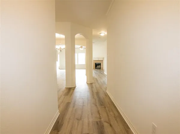 a view of a hallway with wooden floor