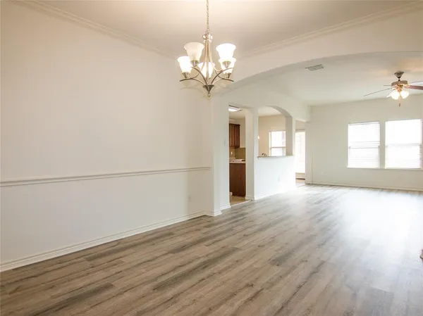 a view of a room with wooden floors and chandelier