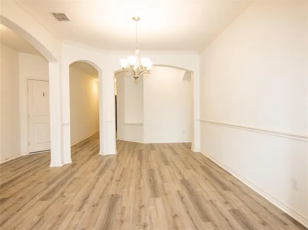 a view of a livingroom with a chandelier fan and wooden floor