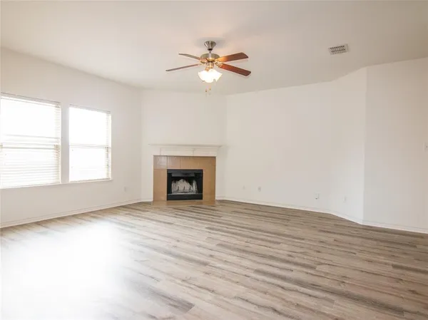 a view of an empty room with a window and fireplace