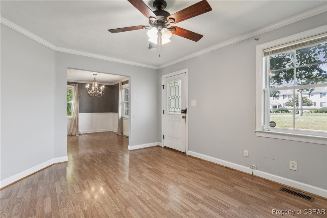 3810 Kecoughtan Road Hampton, VA 23669 - Photo 8 of 40 Unfurnished room with ceiling fan with notable chandelier, crown molding, and light hardwood / wood-style floors