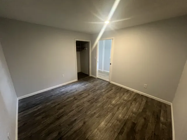 a view of an empty room with wooden floor