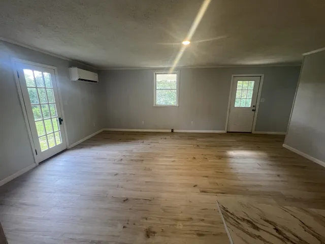 an empty room with wooden floor and windows