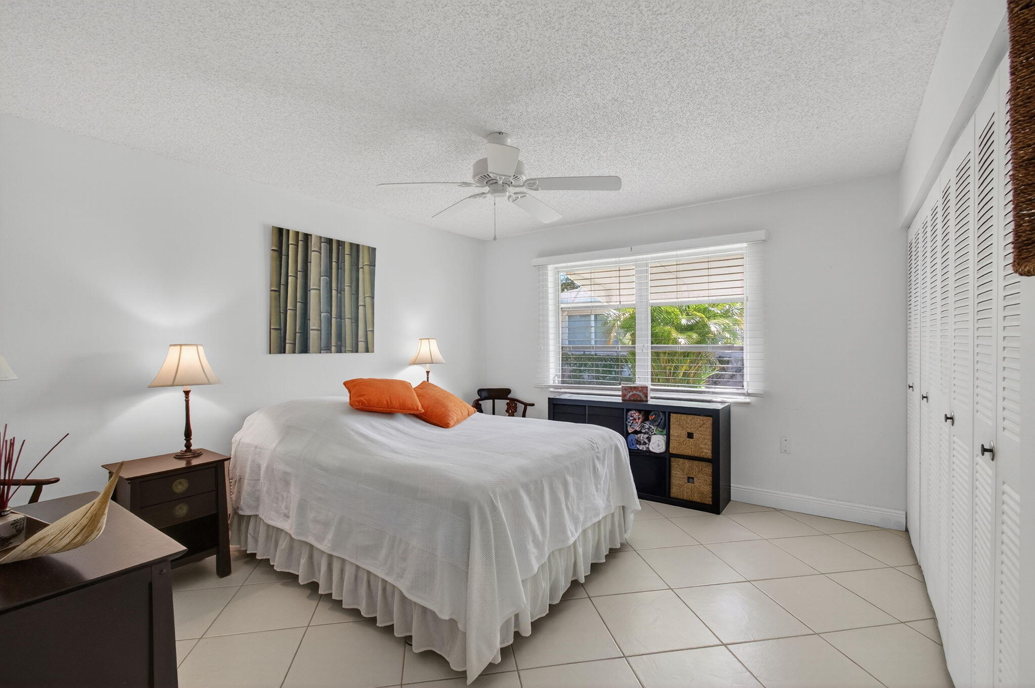 1305 High Point Way Southeast, Unit D Delray Beach, FL 33445 - Photo 23 of 53 a bedroom with a bed and a table lamp
