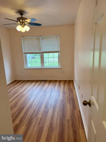 an empty room with windows and fan