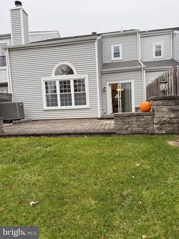 a view of a white house with a yard and potted plants