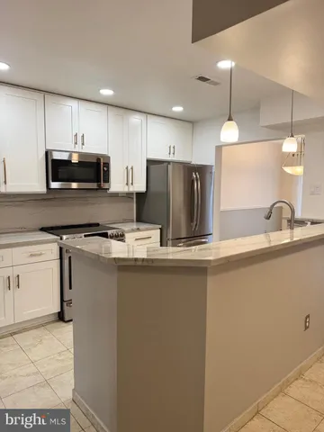 a kitchen with kitchen island a sink stainless steel appliances and cabinets