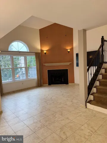 a view of an empty room with a fireplace and a window