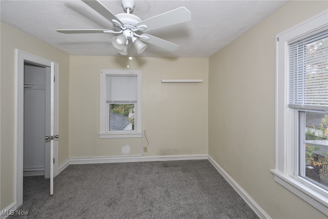 3631 Cummings Road Cleveland, OH 44118 - Photo 26 of 29 Unfurnished bedroom featuring dark carpet, a textured ceiling, and ceiling fan