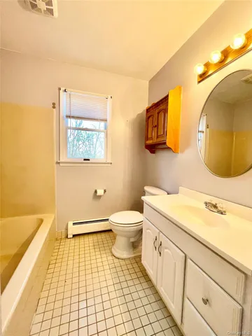 a bathroom with a sink a granite tub and mirror