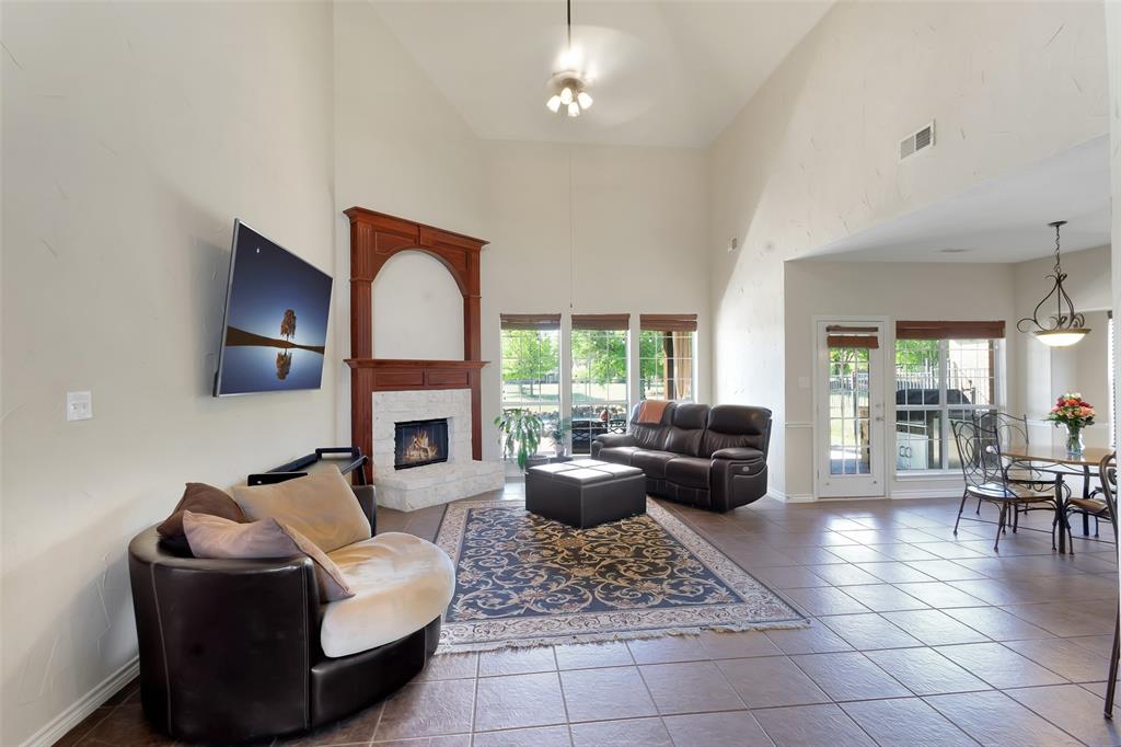 10414 Broadmoor Lane Rowlett, TX 75089 - Photo 11 of 38 Tiled living area with a stone fireplace and a high ceiling