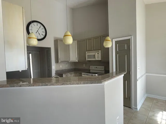 a kitchen with stainless steel appliances granite countertop a sink a refrigerator and a sink