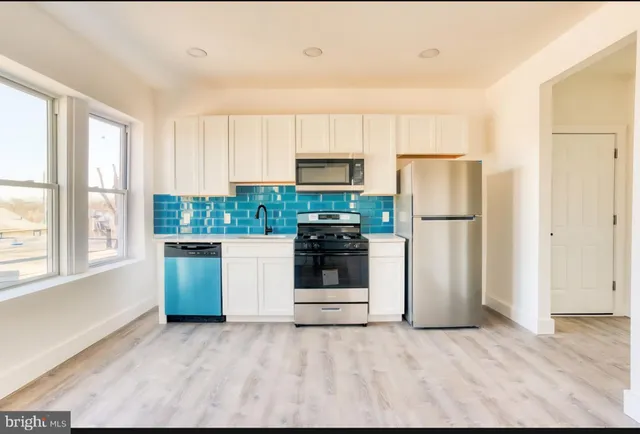 a kitchen with a refrigerator a stove top oven and a refrigerator