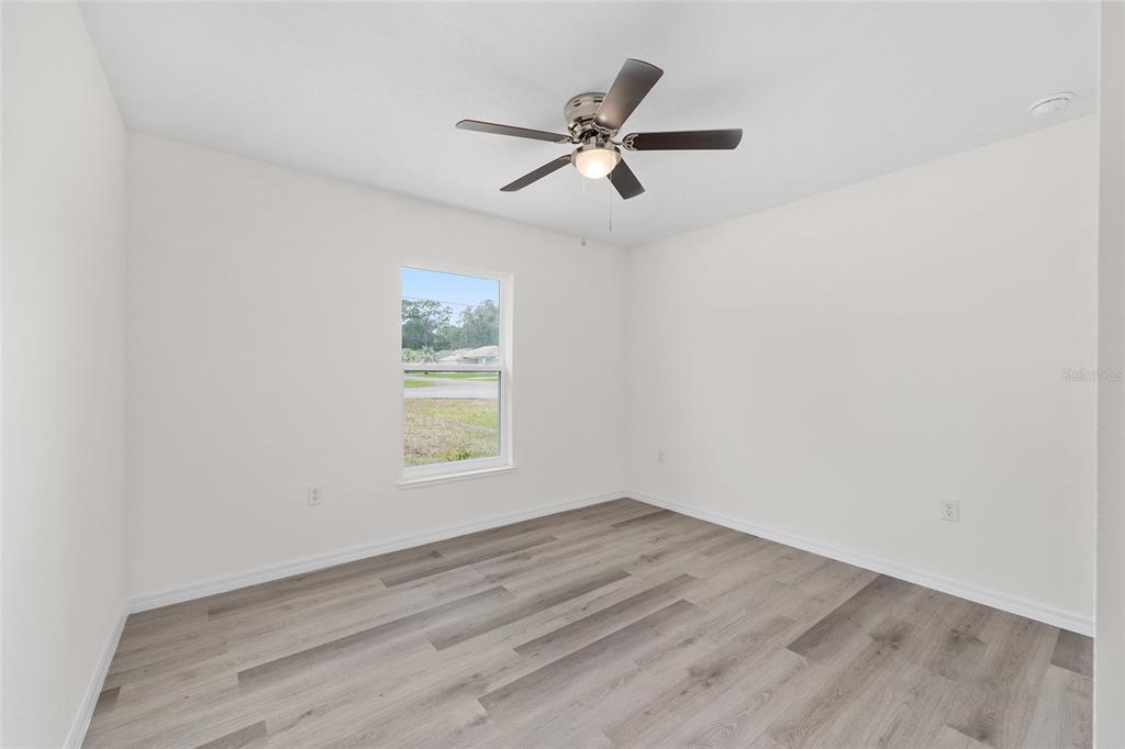 13019 Northeast 7th Loop Silver Springs, FL 34488 - Photo 29 of 35 a view of empty room with wooden floor and fan