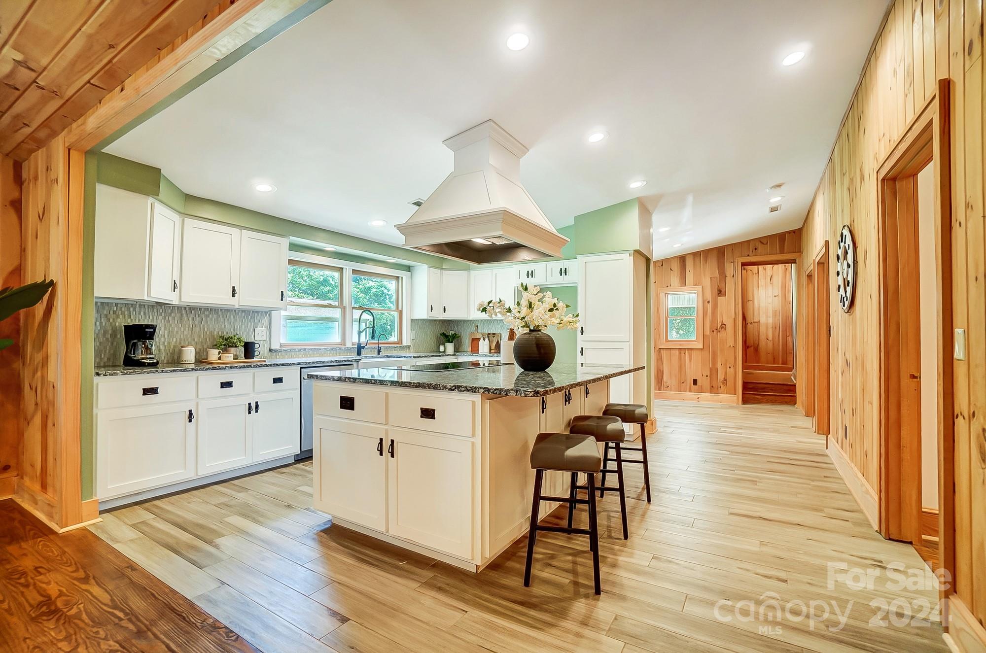6338 Talley Road Stanfield, NC 28163 - Photo 13 of 48 a kitchen with stainless steel appliances kitchen island wooden floors and white cabinets