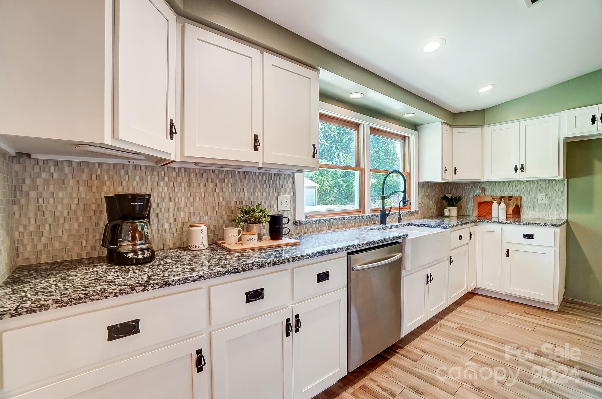 6338 Talley Road Stanfield, NC 28163 - Photo 14 of 48 a kitchen with granite countertop white cabinets white appliances a sink and dishwasher with wooden floor