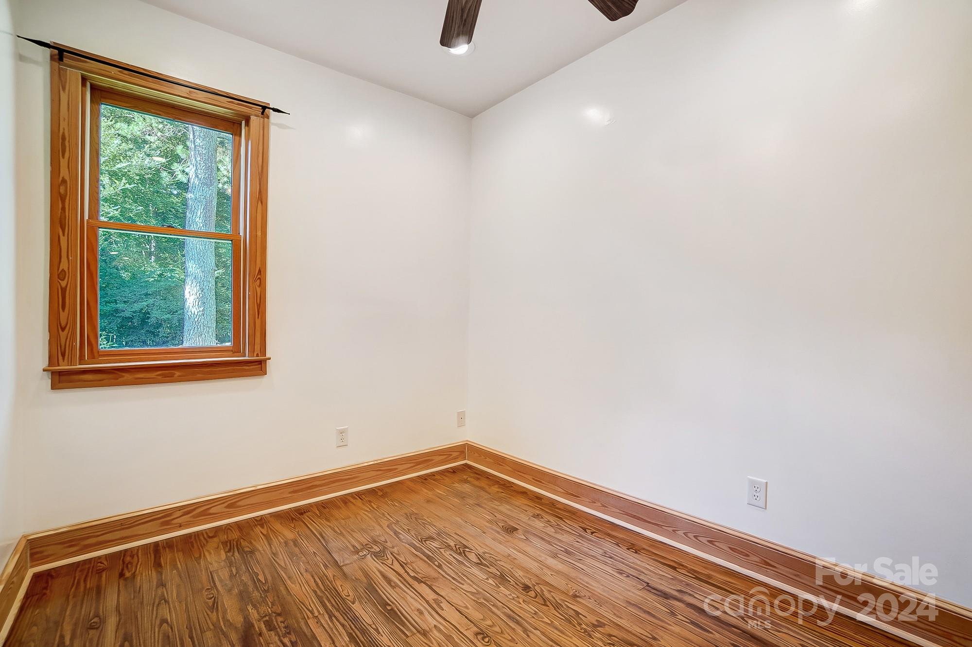 6338 Talley Road Stanfield, NC 28163 - Photo 18 of 48 a view of an empty room with wooden floor and a window