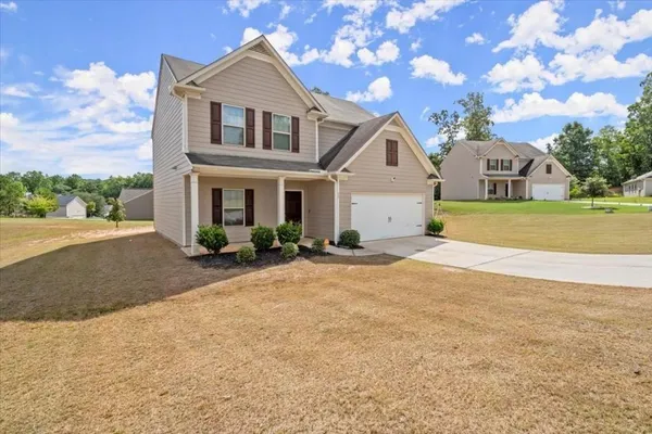 a front view of a house with a yard and garage