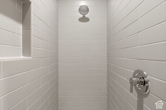 1192 East Ashdown Road Cedar City, UT 84721 - Photo 62 of 96 Tiled shower featuring a rainfall showerhead, polished chrome fixtures, and a recessed niche