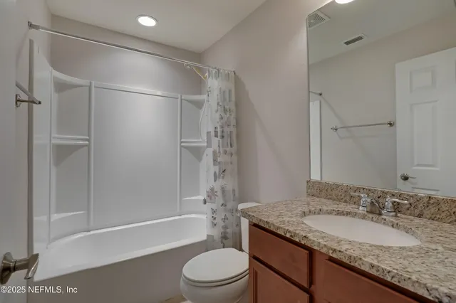 a view of an empty room and chandelier fan