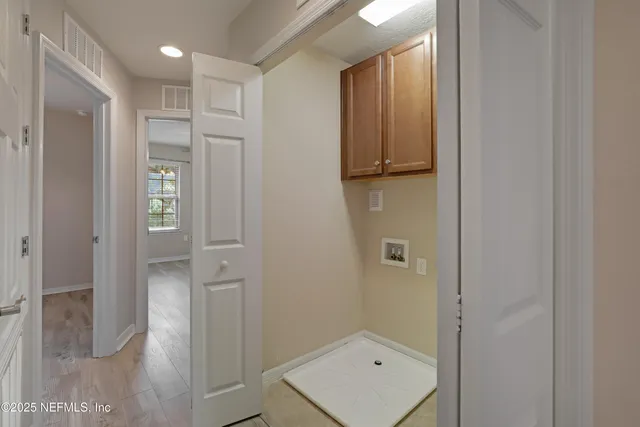 a view of a white house with a big yard and potted plants