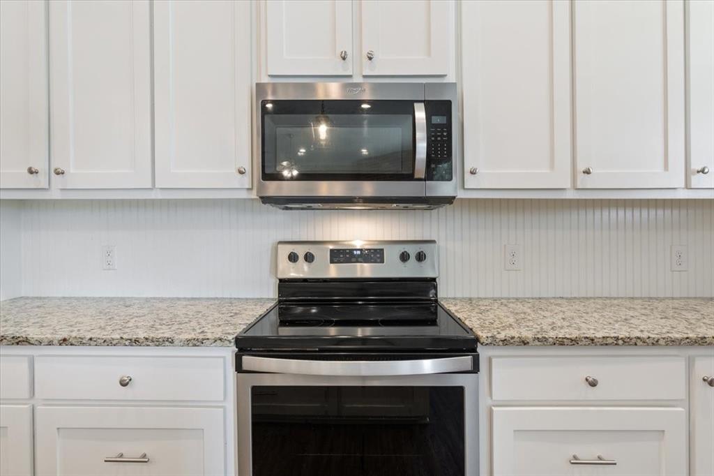 14356 China Spring Road China Spring, TX 76633 - Photo 10 of 36 a kitchen with stainless steel appliances granite countertop white cabinets and a stove top oven