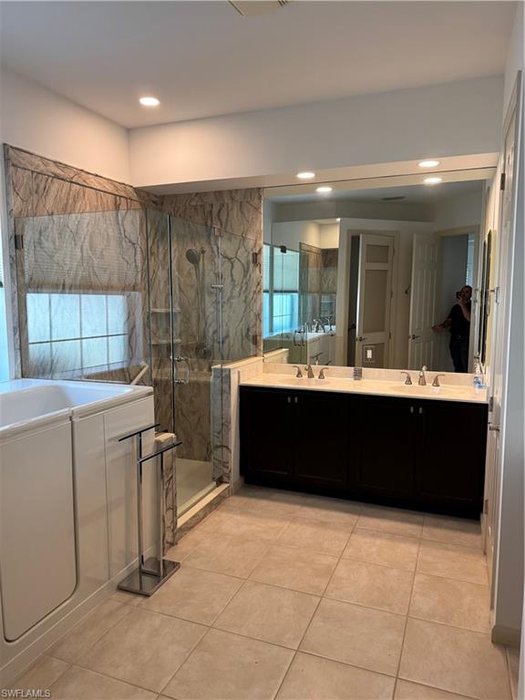 15890 Delasol Lane Naples, FL 34110 - Photo 11 of 16 a bathroom with a sink a mirror and a bathtub