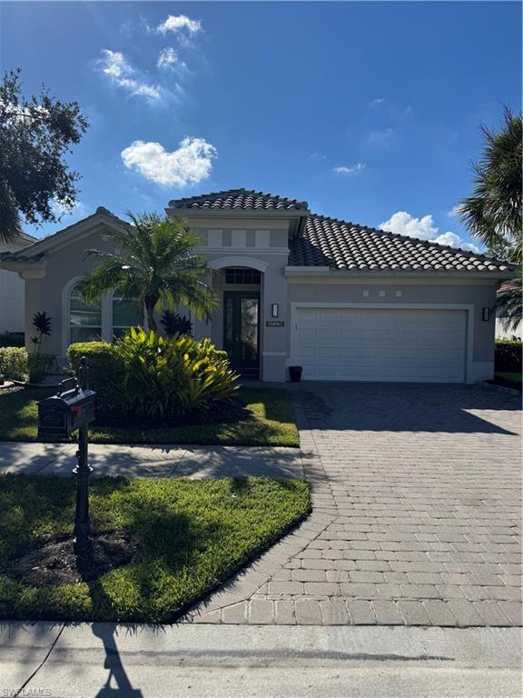 15890 Delasol Lane Naples, FL 34110 - Photo 2 of 16 a front view of a house with a yard