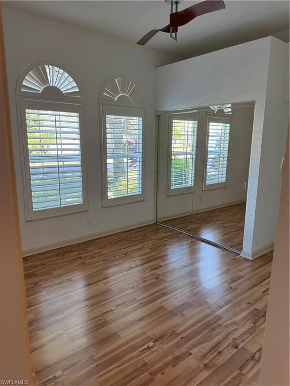 15890 Delasol Lane Naples, FL 34110 - Photo 4 of 16 a view of an empty room with wooden floor and a window