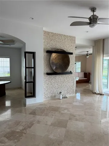 a view of a hallway with windows and chandelier