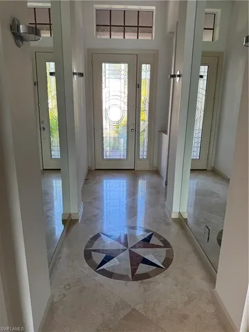 an empty room with large windows and a ceiling fan