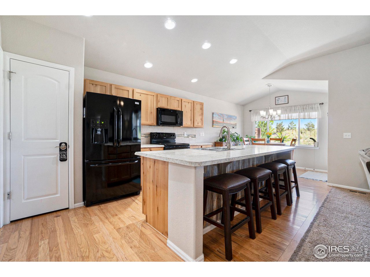 2185 Grain Bin Windsor, CO 80550 - Photo 4 of 22 a kitchen with stainless steel appliances kitchen island granite countertop a refrigerator and a stove top oven