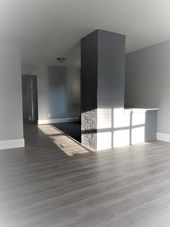 16 Court Street Lowell, MA 01852 - Photo 3 of 14 a view of an empty room with wooden floor and a window