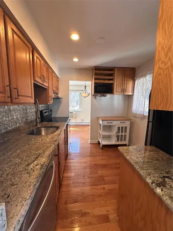 a kitchen with stainless steel appliances granite countertop a stove a sink and a microwave