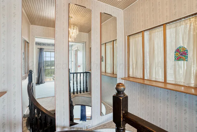 a view of staircase with railing and a chandelier