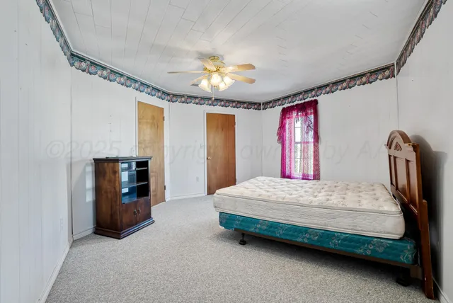 a bedroom with a bed dresser and a window