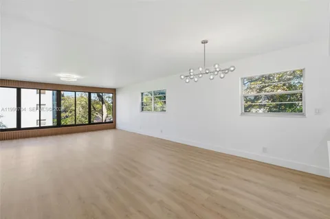 a view of an empty room with wooden floor and fence