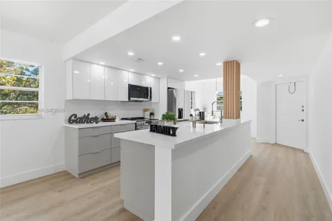 a kitchen with stainless steel appliances granite countertop a sink a stove a refrigerator and a microwave