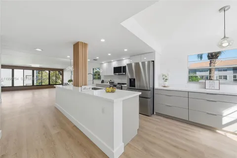 a kitchen with stainless steel appliances a refrigerator sink and cabinets