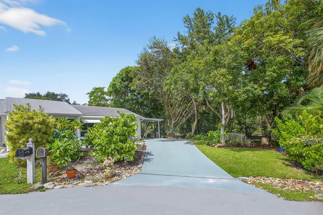 a view of a house with backyard sitting area and garden